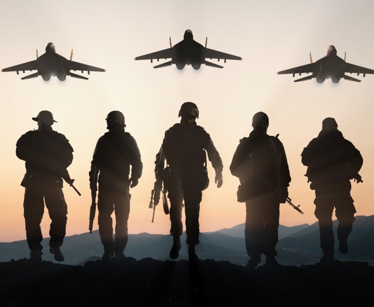 Soldiers walking away from camera with planes overhead