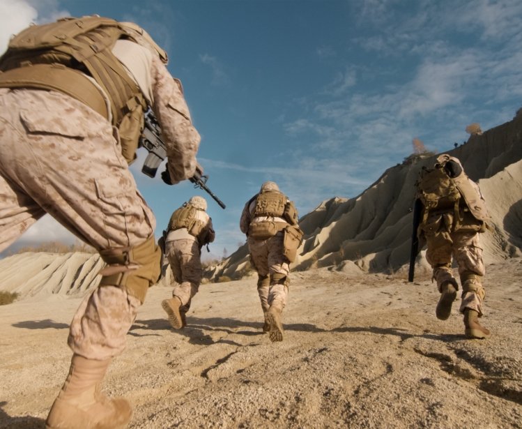 Close-up Shot of Squad of Soldiers Running Forward and Atacking Enemy During Military Operation in the Desert.