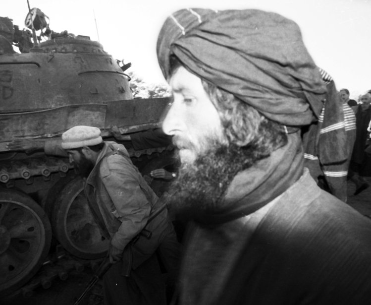 B&w photo of a man in front of tank