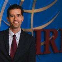 Dr. Daniel Twining standing in front of the IRI logo.