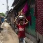 A young boy collects drinking water in his Barisal slum