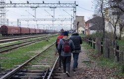 Migrants walking along train tracks in Serbia. Source: Shutterstock.