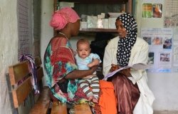 Health extension worker counsels a woman, who is holding her infant, on best nutrition practices. 