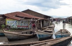  A boy balances on a boat in front of a collapsed house as a result of flash floods in Uganda’s western Rwenzori mountains.
