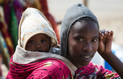 Ethiopian young woman with baby on the back on Addis Ababa Street