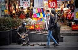 A person and a statue both wear masks on the street to prevent infection from coronovirus during the Chinese New Year in Chengdu, China.