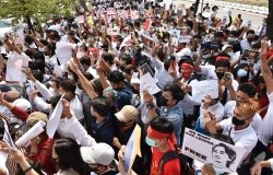 A group of people gather for a protest, many holding signs saying We Want Our Leader Free.