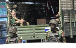 Soldiers stand behind a military vehicle in Myanmar.
