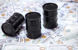 A picture of three oil barrels on a stack of U.S. currency