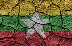 The flag of Myanmar painted on cracked pavement