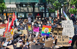 Protestors hold up signage and flags for Black Lives Matter causes