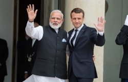 Pictured on the left is the Prime Minister of India, Narendra Modi, and on the right, the President of France, Emmanuel Macron, waving toward the camera.