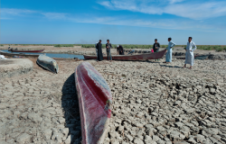Boats on dried cracked earth during a drought in the Southern Marshes of Iraq.