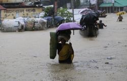 A woman walks through flooded street in Bandarban, Bangladesh.