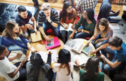 Students gathered around tables speaking with one another