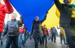 Street protestors hold a giant Ukrainian flag