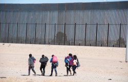 A group of migrants walks near the U.S. border.