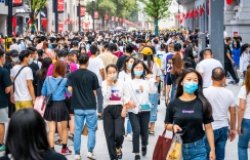 People walking along a street wearing masks in China 