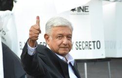 AMLO gives a thumbs up with his ink-stained finger.