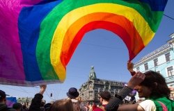 Person waving a pride flag on a busy street