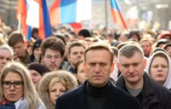 Lyubov Sobol abd Alexei Navalny on march in memory of Boris Nemtsov. People, flag and poster on the background, February 2020.