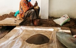 A Congolese man grinding coltan ore.