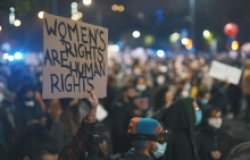 Woman holding up a sign that reads, “WOMEN’S RIGHTS ARE HUMAN RIGHTS,” at a protest against Poland’s abortion laws.