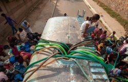 People in New Delhi, India, using hoses to fill jerry cans with drinking water