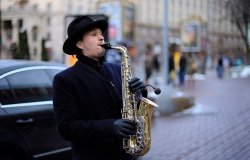 street musician, playing saxophone on a street. March 5, 2019. Kiev, Ukraine