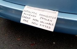 Sign on vehicle warning potential criminals that the catalytic converter has already been stolen and a cheaper part substituted