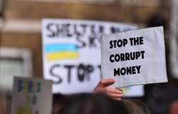 Person holding sign that reads "stop the corrupt money"