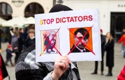 Protest poster with phrase "STOP DICTATORS" and satirical images of Putin and Lukashenko