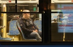 Image of a man on a bus through the bus's window 