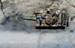 People climb on a destroyed russian tank after russian attack in Febrary