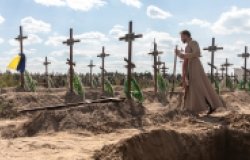 A priest overseas the burial of the remains of 13 unidentified and two identified people who were killed in the Bucha district during the Russian occupation