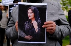 Protester holding photo of Mahsa Amini