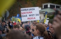 A man in Warsaw, Poland holds a sign protesting the Russian invasion of Ukraine