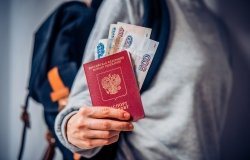 Tourist holds Russian passport and Russian roubles
