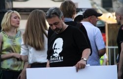 Man holding sign with shirt supportingAles Bialiatski