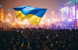 Meeting on the Independence square at night in Kiev. Girl holding a flag of Ukraine. During revolution to support the integration of Ukraine into the European Union.